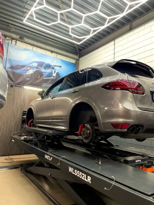 Grijze auto op de brug voor reparatie en onderhoud